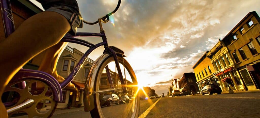 Low angle view of cruiser bike being ridden down Telluride's main street during a summer sunset.