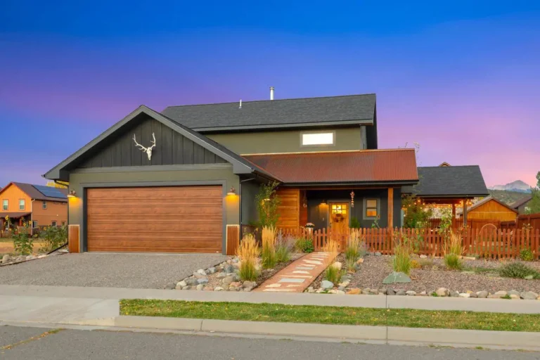 Real estate listing 746 North Laura Street, Ridgway, Colorado illuminated exterior at dusk with Just Listed banner.