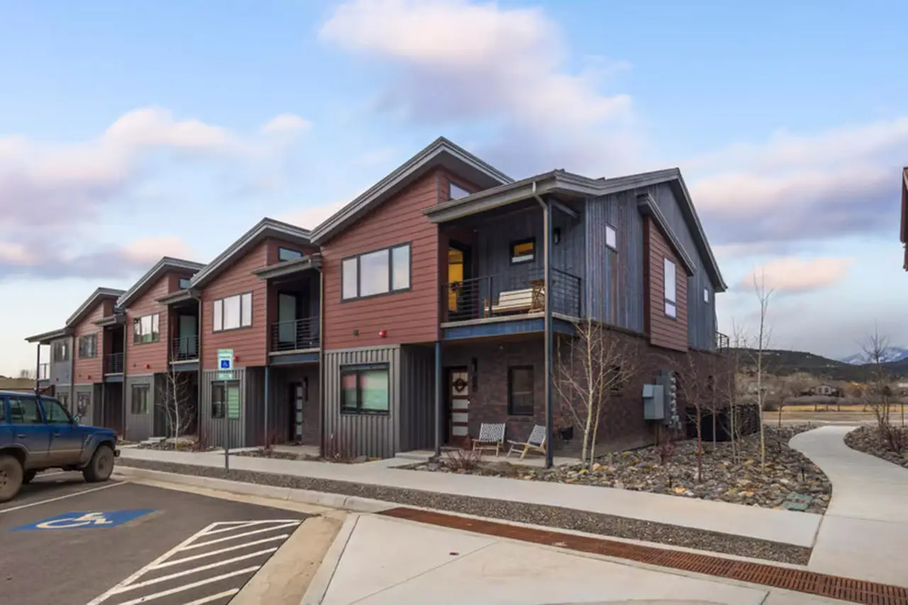 410 N Lena Street, Ridgway, Colorado real estate listing exterior with blue skies and fluffy clouds.