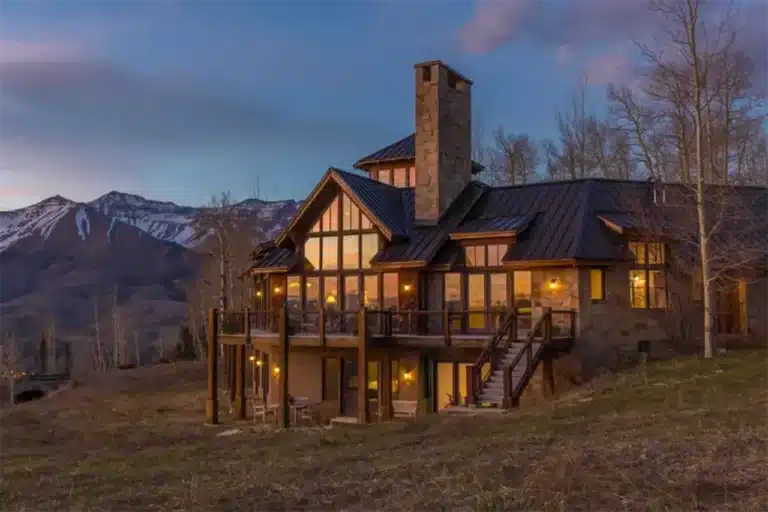 Illuminated exterior at dusk of Shimkonis Partners real estate listing 404 Benchmark Drive in Mountain Village, Colorado.