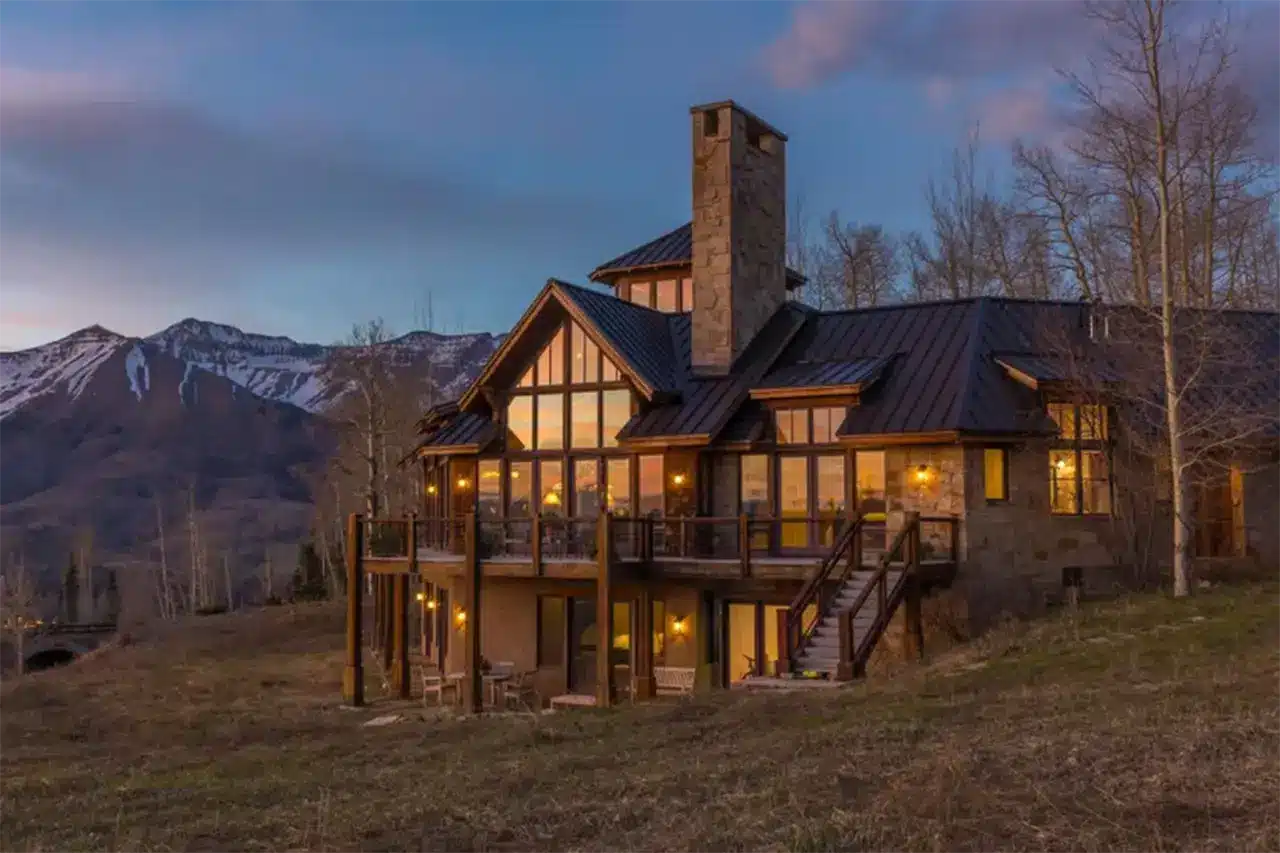 Illuminated exterior at dusk of Shimkonis Partners real estate listing 404 Benchmark Drive in Mountain Village, Colorado.