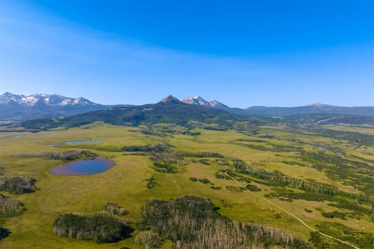 Laughing dog 182 Shimkonis Partners Telluride area real estate listing, Laughing Dog Ranch: a rare 243 acre sanctuary, summer blue sky aerial view with lakes and mountains