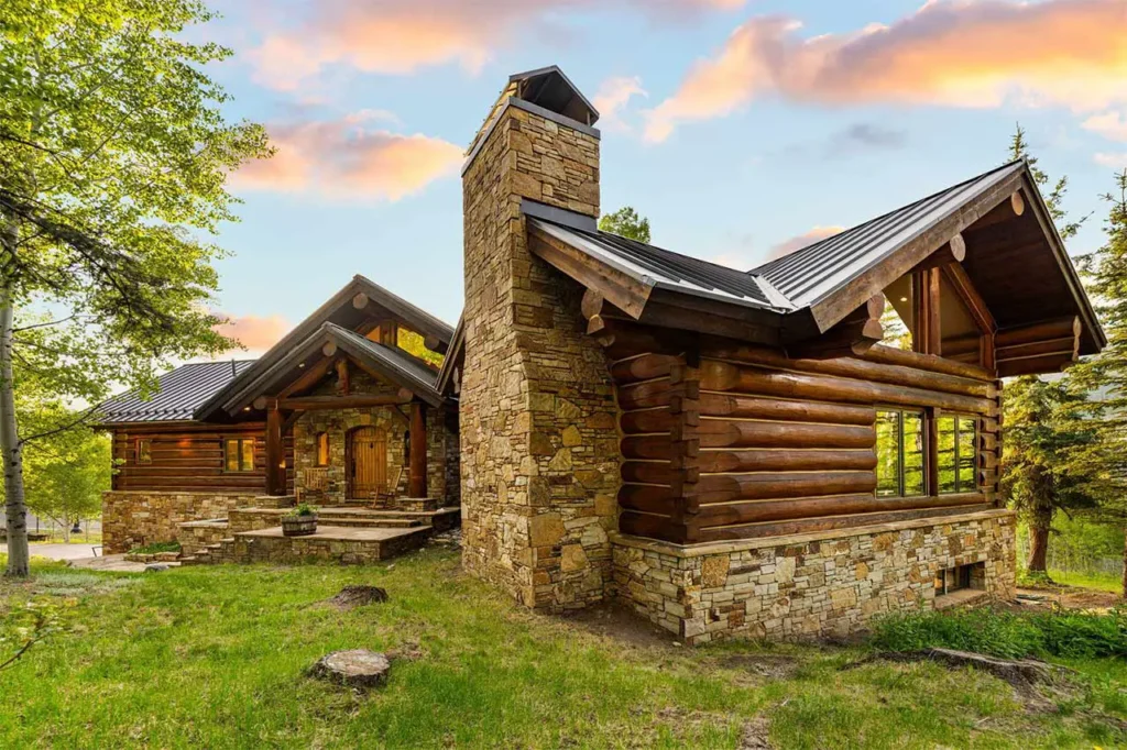 Illuminated exterior view of Shimkonis Partners Telluride area real estate listing, 103 Birdie Drive, Mountain Village, featuring grassy yard