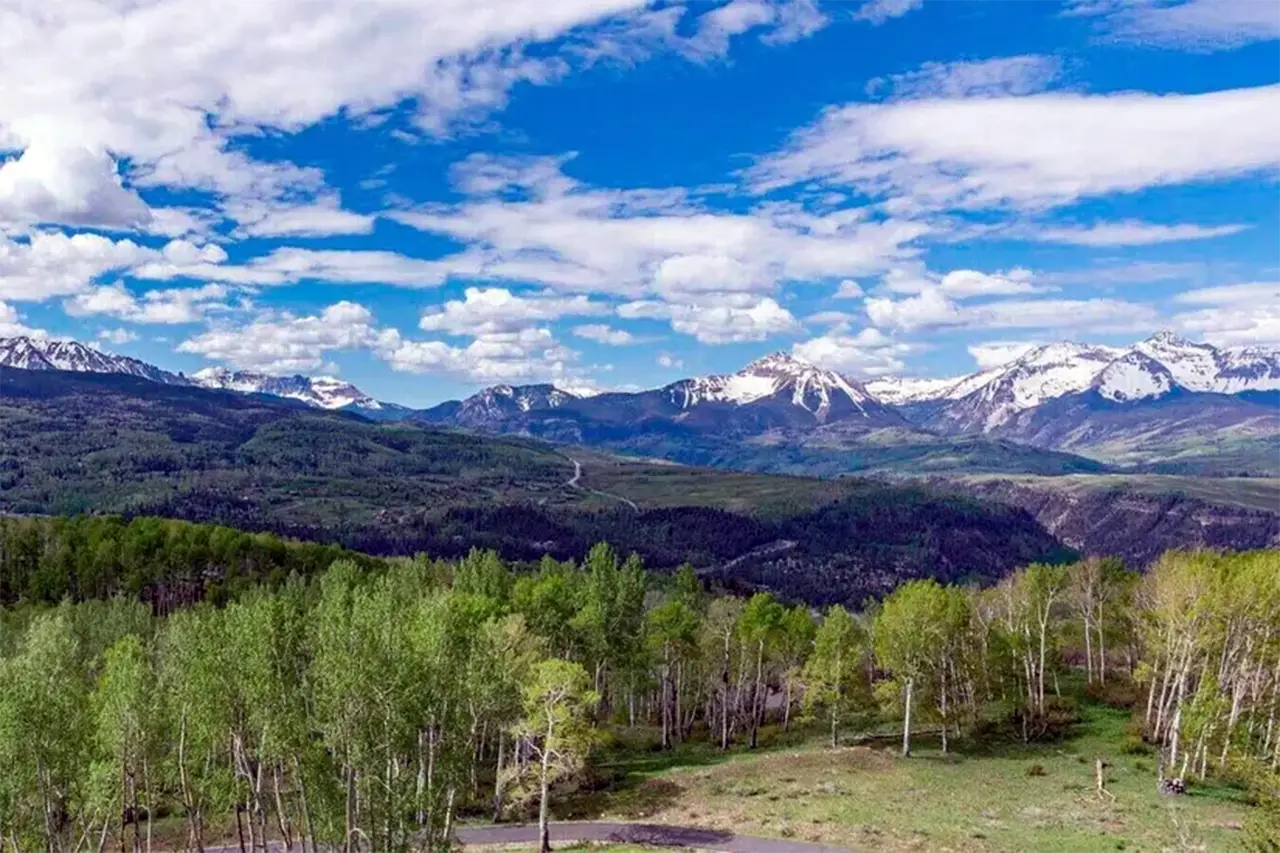 Telluride real estate listing Christina’s Way Aldasoro neighborhood property with spring aspens and bluebird, snowy mountain views.
