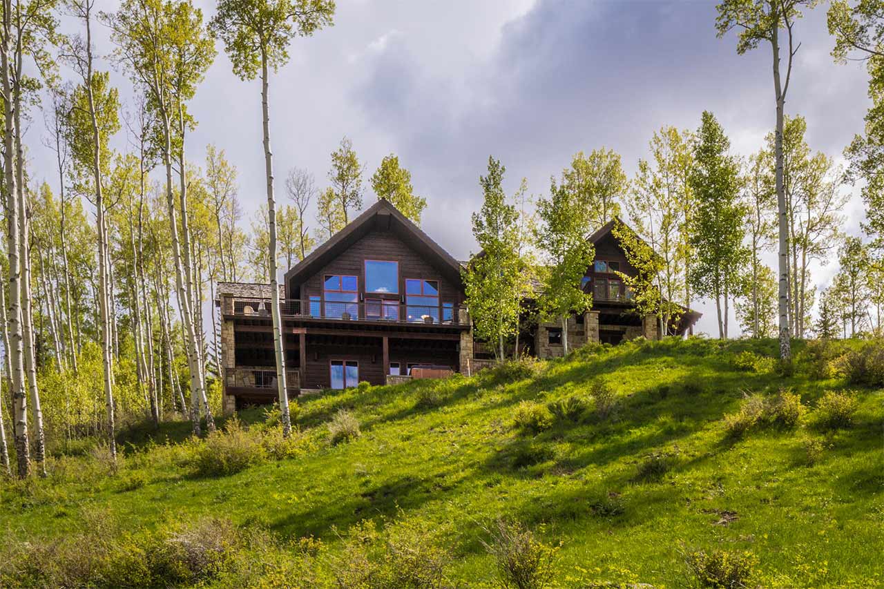 Sunny summer exterior view of Shimkonis Partners Telluride real estate listing, 107 Joaquin Road, Telluride