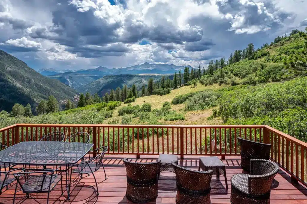 Summer deck view from Shimkonis Partners Telluride area real estate listing, 1075 High Plains Drive, Placerville with expansive mountain and canyon views