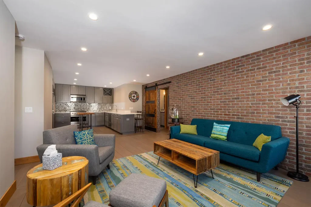 Bright living area of Shimkonis Partners Telluride real estate listing, Black Bear #302, with kitchen and bedroom entrance